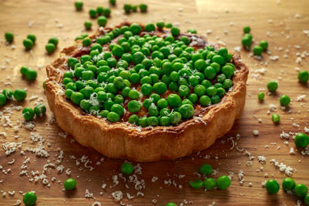 Homemade Cheese and sweet pea quiche, tart on wooden board