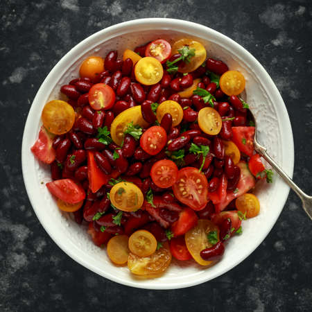 Healthy Red beans and mix of organic red and yellow cherry tomatoes salad topped with parsley.の写真素材