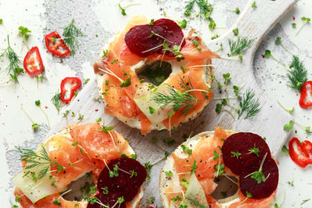 Smoked salmon bagel toasts with soft cheese, cucumber ribbons and beetroot and dill, cress salad