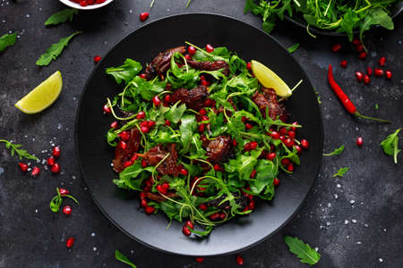 Spicy crispy duck salad with pomegranate seeds, lime and wild green rucolaの写真素材