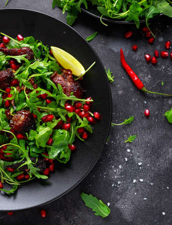 Spicy crispy duck salad with pomegranate seeds, lime and wild green rucola