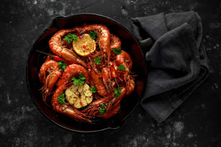 Tiger prawns fried in butter with, lemon juice, garlic and white wine served in cast iron skillet with parsleyの写真素材