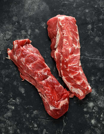 Raw lamb shoulder fillets on black table, backgroundの写真素材