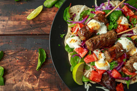 Lamb mint kebabs with flatbread, mix of vegetables, lime and greek yoghurt chilli sauceの写真素材