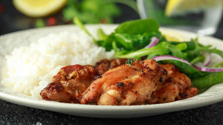 Roasted boneless skinless chicken thighs with rice and green vegetables mixの写真素材