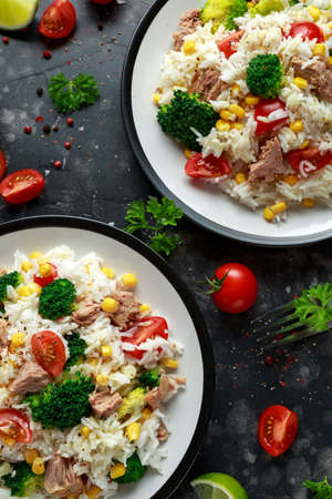 Fresh Tuna rice salad with sweet corn, cherry tomatoes, broccoli, parsley and lime in black bowlの写真素材