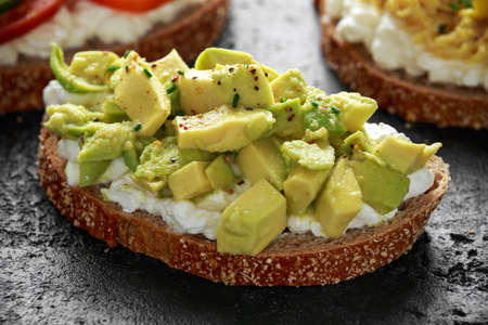 Vegetarian Healthy bread toasts with cottage cheese, heirloom tomatoes, scrambled eggs and avocado