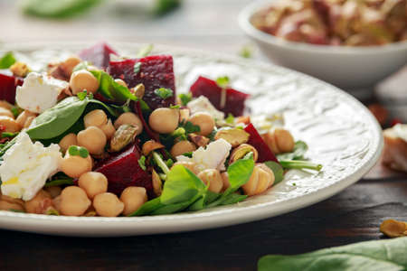 Healthy Beet Salad with chickpeas, pistachios nuts, feta cheese on rustic wooden backgroundの写真素材