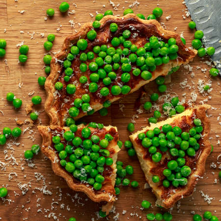 Homemade Cheese and sweet pea quiche, tart on wooden boardの写真素材