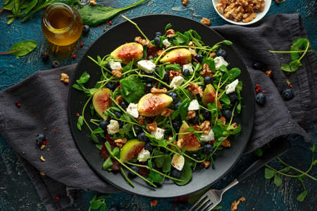 Figs salad with blueberries, walnuts, feta cheese and green vegetables. healthy foodの写真素材