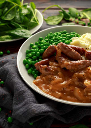 Mashed potatoes and sausages, bangers with onions gravy, green peasの写真素材