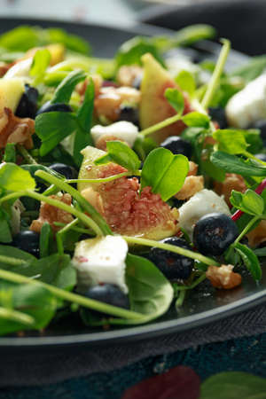 Figs salad with blueberries, walnuts, feta cheese and green vegetables. healthy foodの写真素材