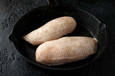 Raw duck brest fillets on rustic cast iron pan, skilletの写真素材