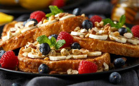 French cinnamon toast with blueberries, raspberries, banana, nuts, hazelnut and honey.