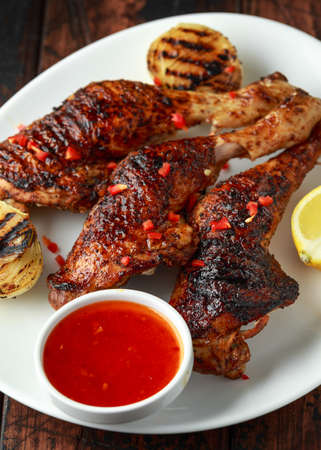 Grilled chicken legs with lemon and sweet chilli sauceの写真素材