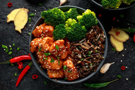 Teriyaki chicken, steamed broccoli and wild rice served in two Asian clay bowlsの写真素材