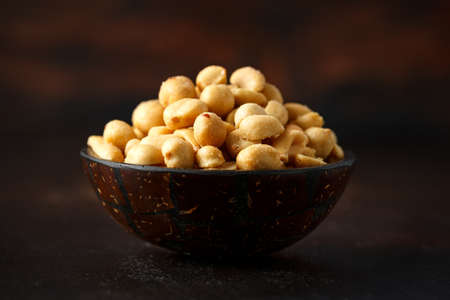 Roasted salted peanuts in coconut bowl, pub snackの写真素材