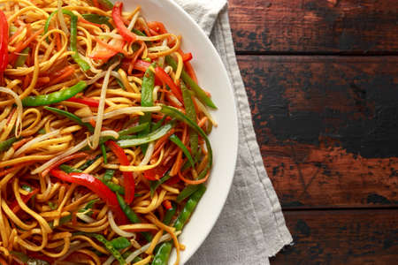 Chow mein, noodles and vegetables dish with wooden chopsticksの写真素材