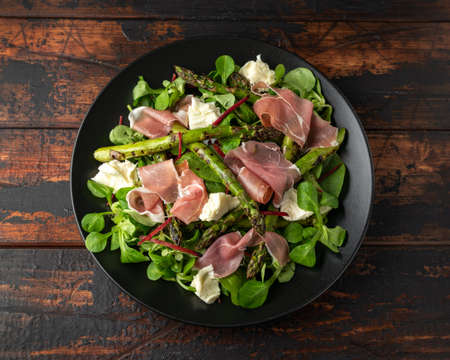 Grilled Asparagus, parma ham salad with mozzarella cheese and green vegetablesの写真素材