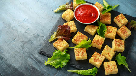 Spanish Potato Frittata tapas with tomato sauce on stone boardの写真素材