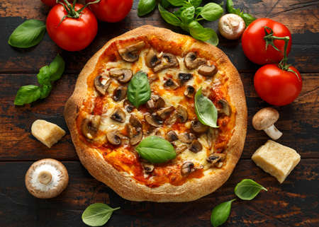 Hot Mushroom Pizza with basil, tomatoes, mozzarella and parmesan cheese on wooden table. ready to eat. vegetarian food.の写真素材