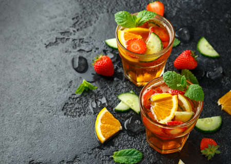 Refreshing Pimms Cocktail with Fruit and vegetables on rustic black table.の写真素材