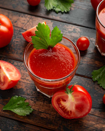 Tomato juice in glass with celery on rustic wooden tableの写真素材