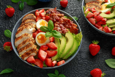 Chicken Cobb salad with strawberries, bacon, avocado and boiled eggs.の写真素材