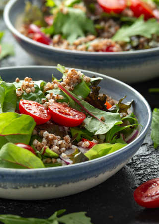 Buckwheat salad with cherry tomatoes, red onion and green vegetables. Healthy diet foodの写真素材