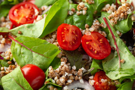 Buckwheat salad with cherry tomatoes, red onion and green vegetables. Healthy diet foodの写真素材