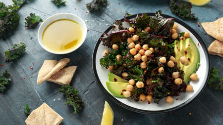 Kale Chickpeas, avocado salad with lemon on plate. Healthy food.の写真素材