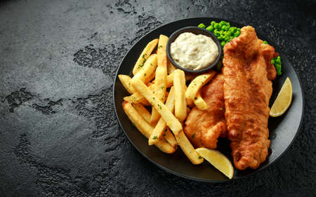 British Traditional Fish and chips with mashed peas, tartar sauce and cold beer.