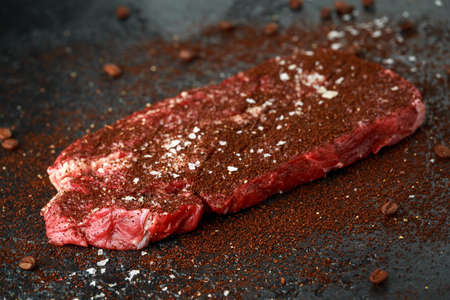 Ready to cook seasoned with home made coffee rub beef steak on dark background.の写真素材