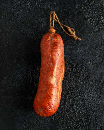 traditional Balearic raw cured meat sobrassada sausage made from ground pork, paprika and spices on rustic black backgroundの写真素材