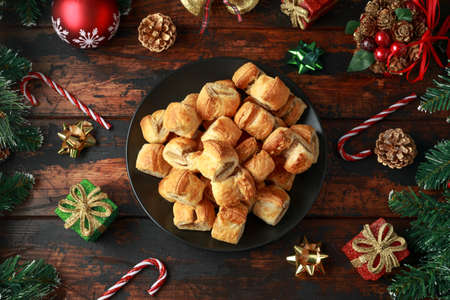 Christmas Sausage Rolls with decoration, gifts, green tree branch on wooden rustic tableの写真素材
