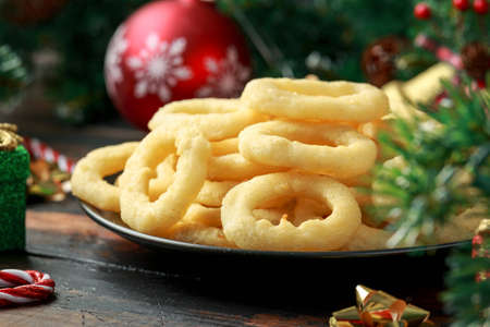 Christmas Onion rings with decoration, gifts, green tree branch on wooden rustic table
