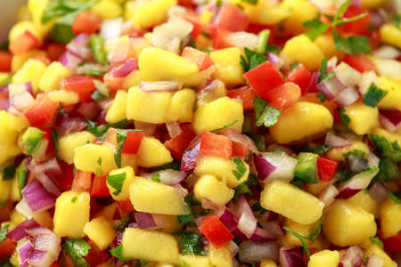 Bowl of fresh Mango Salsa with nachos chips and herbs. Healthy Vegan, Vegetables food.の写真素材