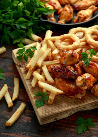 Fried Chicken wings with onion rings, french fries and dipping sauce. take away food
