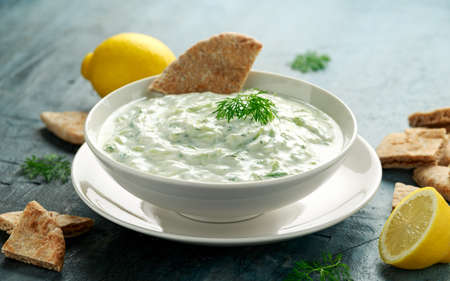 Tzatziki dip sauce with greek yogurt, garlic, dill and cucumber in white bowl.の写真素材