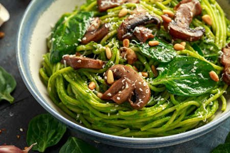 Vegan garlic mushroom pasta with spinach and avocado pesto drizzled with sesame seeds and roasted pine nutsの写真素材
