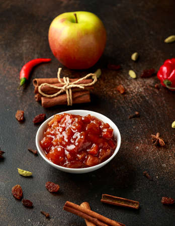 Homemade apple and chilli chutney with spices on dark background.の写真素材