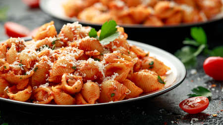 Conchiglie rigate pasta with chickpeas in tomato sauce with parmesan cheese. Healthy vegan food.の写真素材