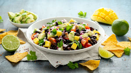 Avocado, mango salad with black bean, tomato, red onion and tortilla chips. healthy foodの写真素材