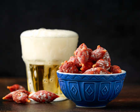 Cocktail chorizo mini spicy pork fermented dry cured salami sausages with beerの写真素材