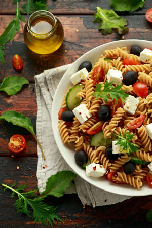 Pasta salad with tomato, black olives, cucumber and feta cheese. healthy food