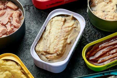 Canned fish with different assortment types of seafood on rustic stone background.の写真素材