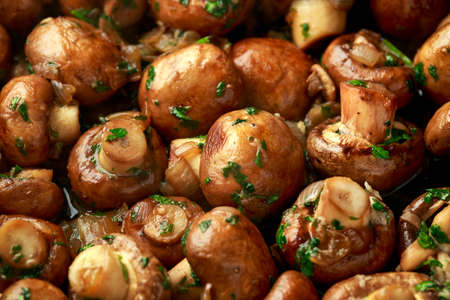 Fried mushrooms with onion and garlic in iron cast panの写真素材