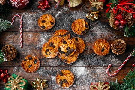 Christmas Chocolate Florentines cookies with almond and raisins with decoration, gifts, green tree...
