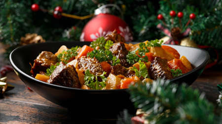 Christmas Beef Stew with decoration, gifts, green tree branch on wooden rustic tableの写真素材