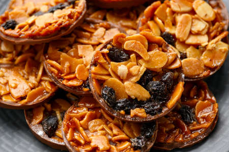 Christmas Chocolate Florentines cookies with almond and raisins with decoration, gifts, green tree branch on wooden rustic tableの写真素材
